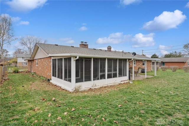 back of property featuring a lawn and a sunroom