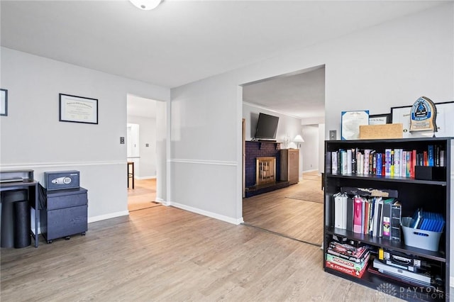 office featuring hardwood / wood-style flooring and a brick fireplace