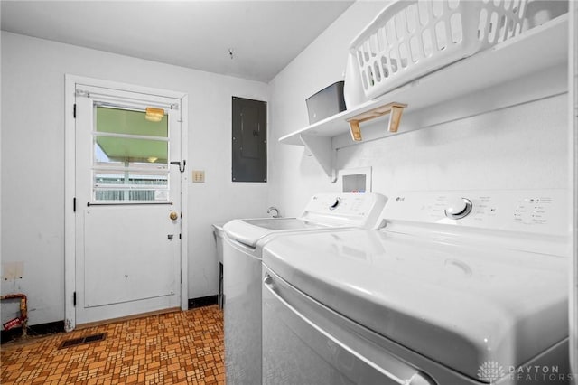 laundry area featuring electric panel and separate washer and dryer