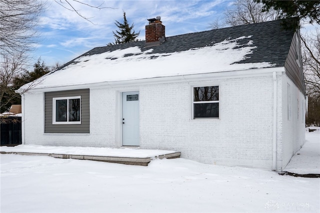 view of snow covered rear of property