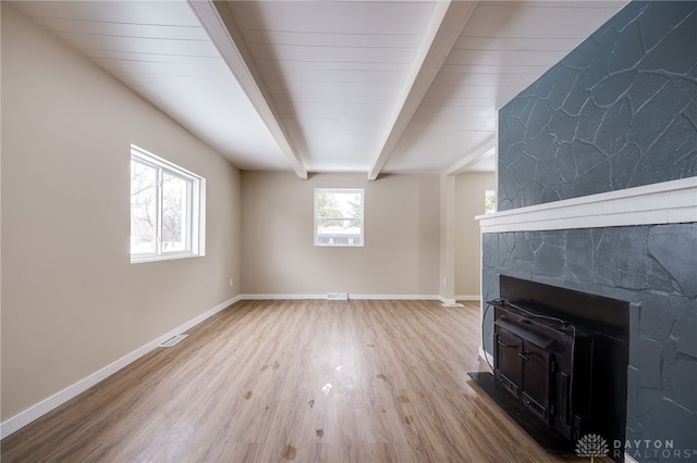 unfurnished living room with hardwood / wood-style flooring and beam ceiling