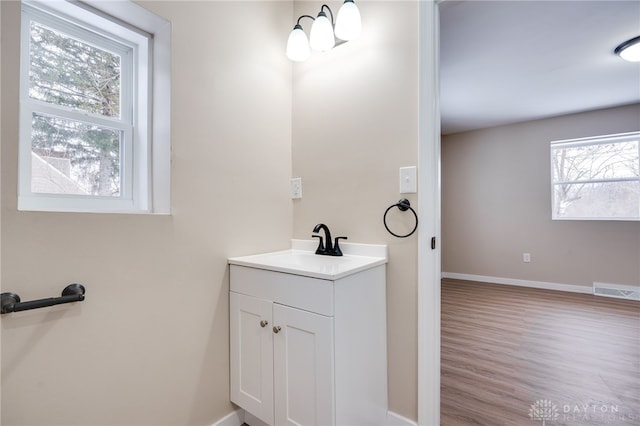 bathroom with vanity, wood-type flooring, and a notable chandelier