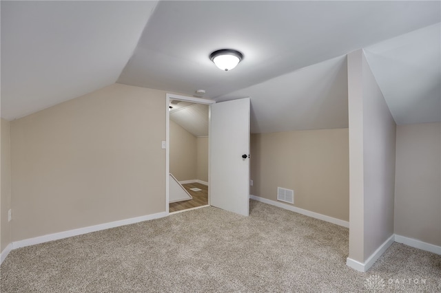 additional living space with light colored carpet and lofted ceiling