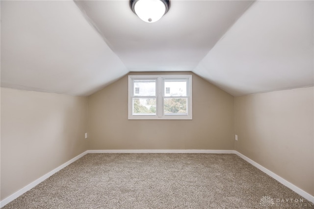 bonus room with carpet floors and vaulted ceiling