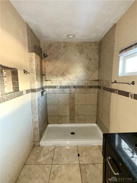 bathroom featuring tile patterned flooring and tiled shower