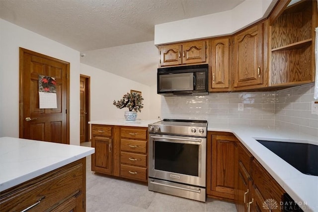 kitchen featuring black appliances, sink, backsplash, and a textured ceiling