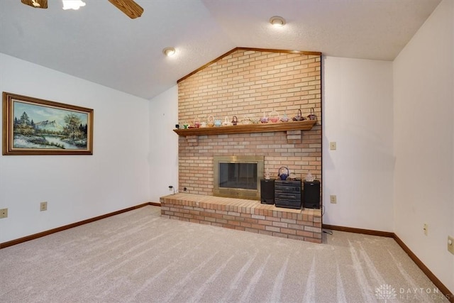 unfurnished living room with lofted ceiling, a fireplace, light colored carpet, and ceiling fan