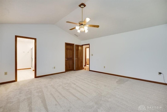 unfurnished bedroom featuring vaulted ceiling, ensuite bath, ceiling fan, and light carpet