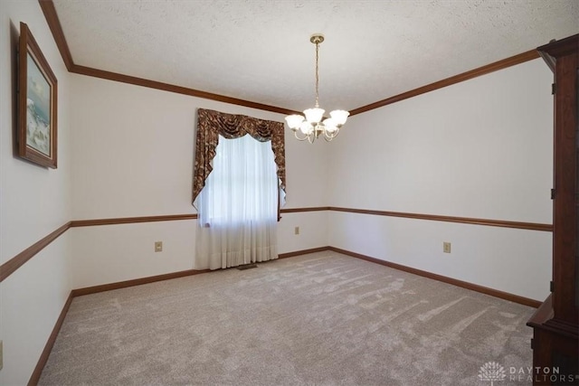 carpeted spare room featuring a textured ceiling, crown molding, and a chandelier