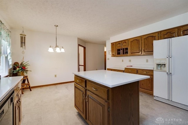 kitchen with a textured ceiling, pendant lighting, a kitchen island, an inviting chandelier, and white fridge with ice dispenser