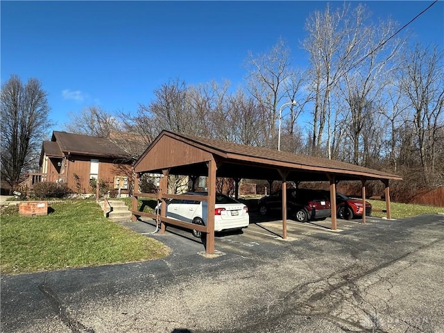 view of parking / parking lot with a carport and a lawn