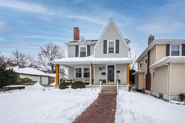 view of front of house featuring a garage, covered porch, and an outbuilding