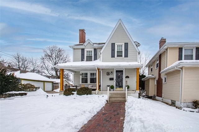 view of front of house featuring an outbuilding, a porch, and a garage