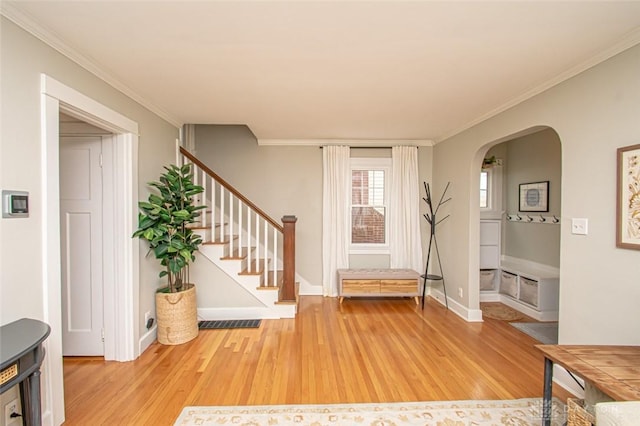 foyer entrance featuring ornamental molding and light hardwood / wood-style flooring