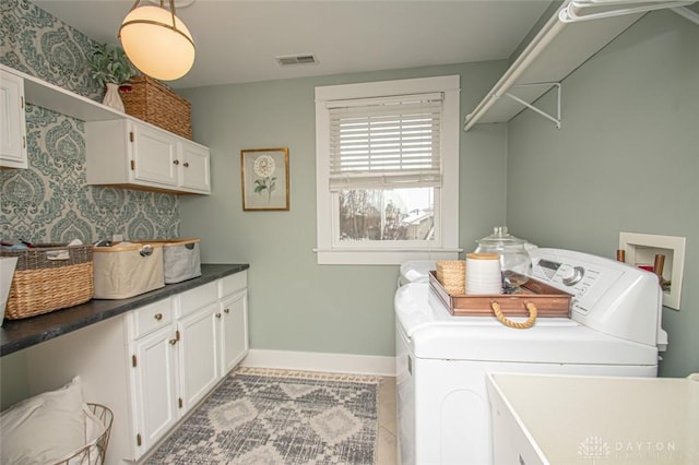 laundry area with cabinets, light tile patterned floors, and washer and clothes dryer