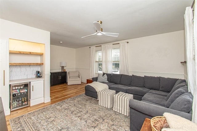 living room featuring bar, hardwood / wood-style floors, beverage cooler, and ceiling fan