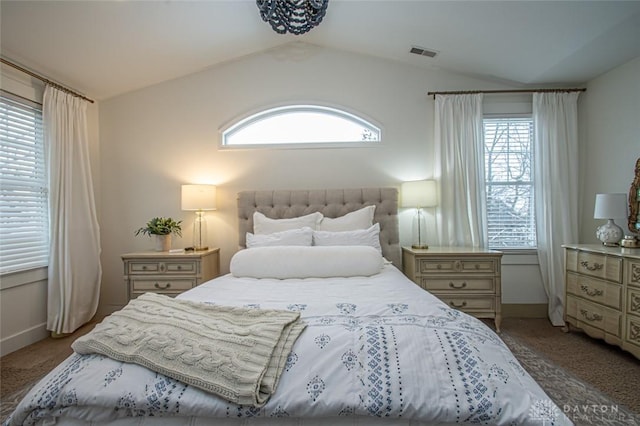 carpeted bedroom with multiple windows and vaulted ceiling