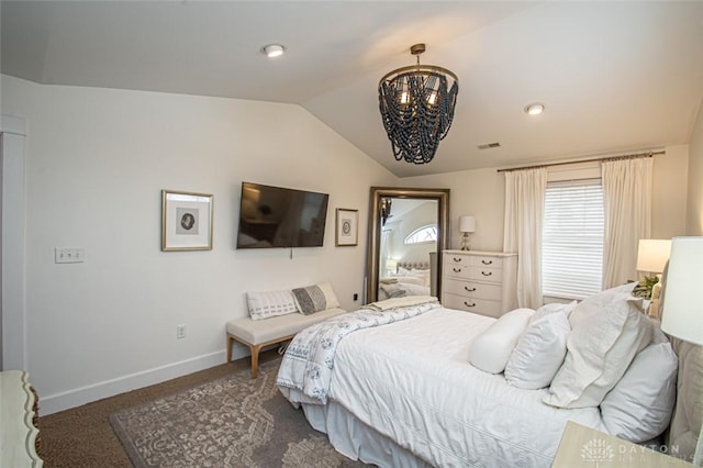 bedroom with dark colored carpet, vaulted ceiling, and an inviting chandelier