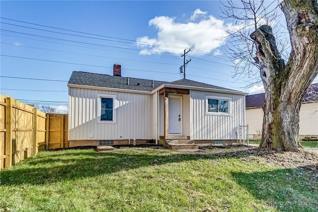 rear view of property featuring a lawn