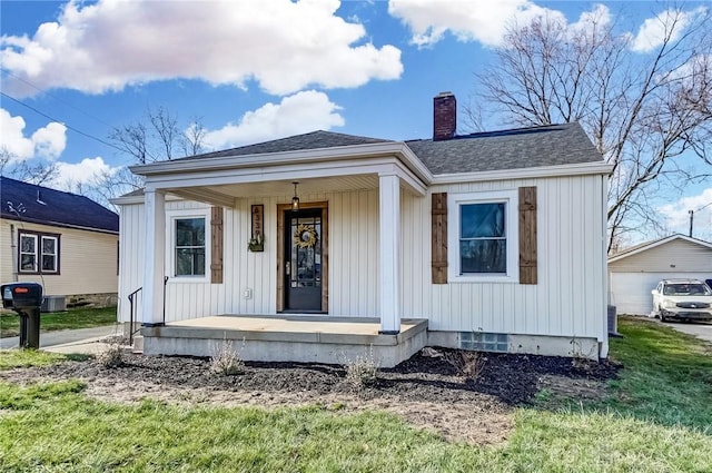 view of front of home featuring a porch, a front lawn, and a garage