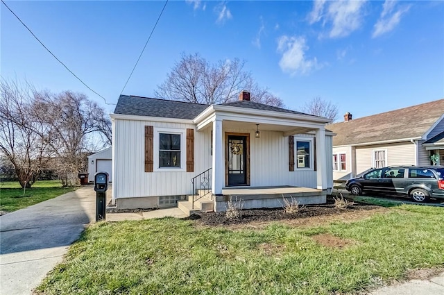 view of front of home with a garage, covered porch, and a front lawn