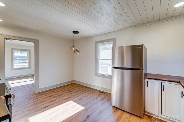 kitchen featuring decorative light fixtures, stainless steel appliances, white cabinetry, and plenty of natural light