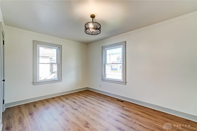 unfurnished room with light hardwood / wood-style floors and crown molding