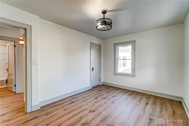 spare room featuring crown molding and light hardwood / wood-style flooring