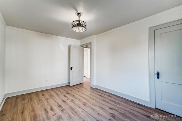 unfurnished room with light hardwood / wood-style floors and ornamental molding