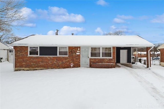 ranch-style home featuring a carport and brick siding