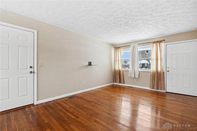 foyer entrance with a textured ceiling and hardwood / wood-style floors