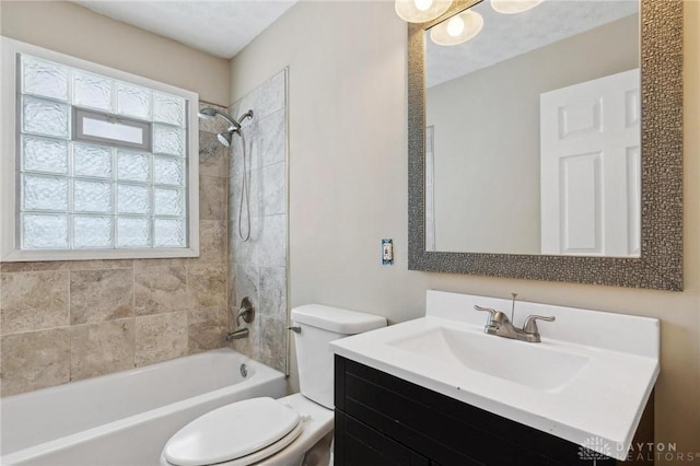 bathroom with tub / shower combination, vanity, and toilet