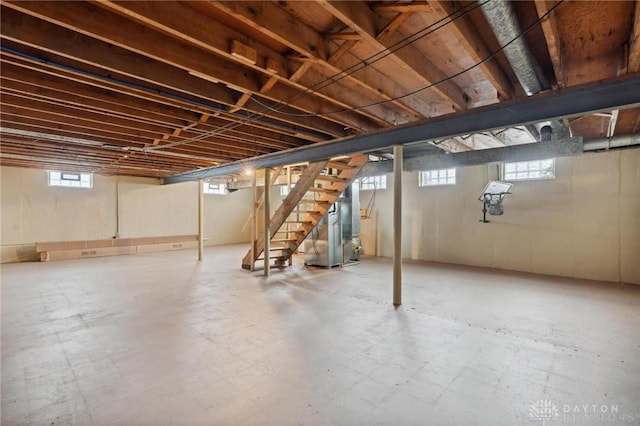 below grade area with stairway, plenty of natural light, and heating unit