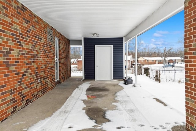 snow covered patio featuring fence