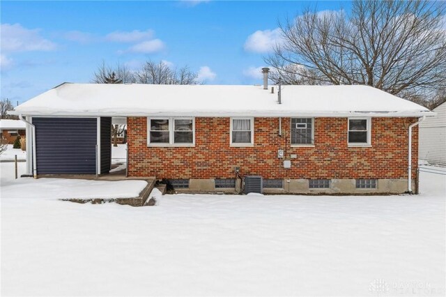 snow covered property featuring central AC