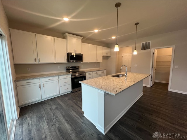 kitchen featuring appliances with stainless steel finishes, sink, white cabinetry, light stone counters, and an island with sink