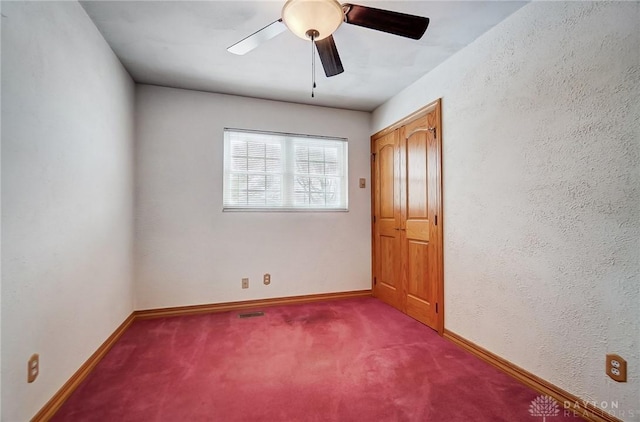 empty room with carpet flooring and ceiling fan