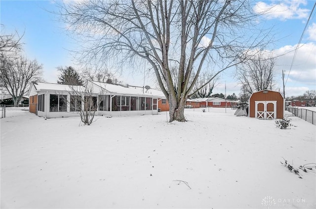 snowy yard with a sunroom