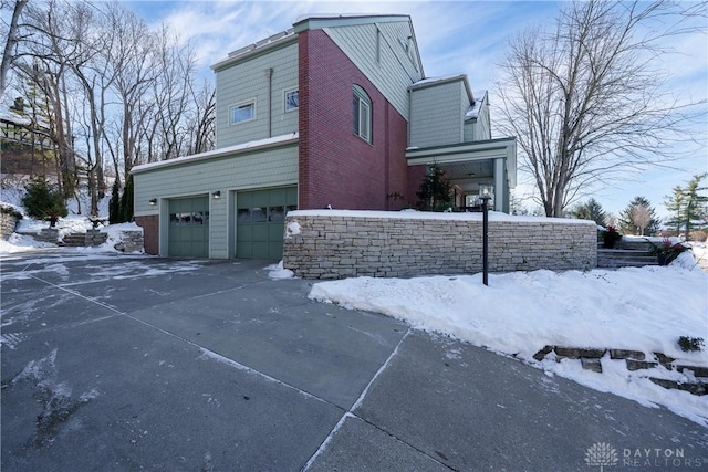 snow covered property featuring a garage