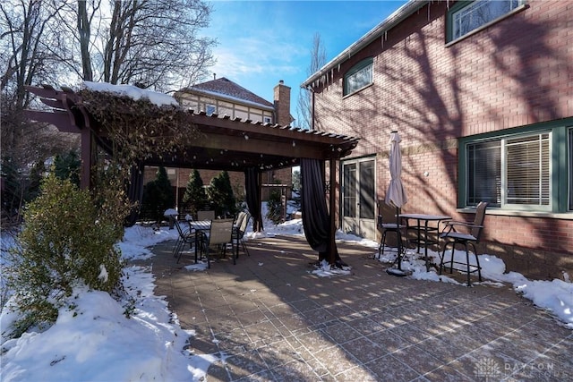 snow covered patio with a pergola