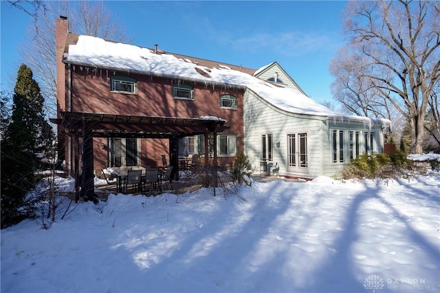 snow covered property with a pergola