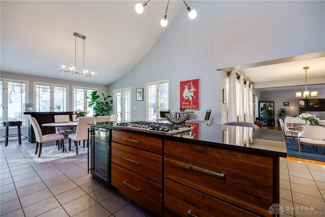 kitchen with high vaulted ceiling, wine cooler, dark tile patterned flooring, and a center island