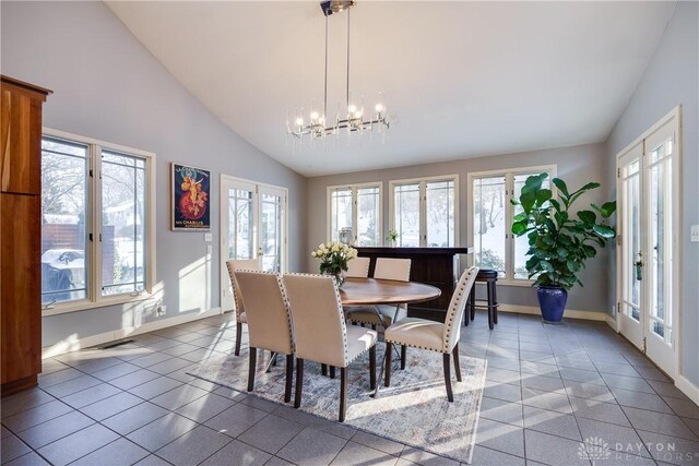 dining room featuring lofted ceiling, tile patterned flooring, french doors, and a chandelier