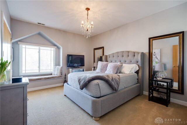 carpeted bedroom featuring a notable chandelier