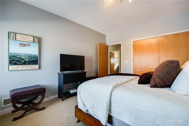 carpeted bedroom featuring lofted ceiling and a closet