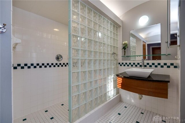 bathroom with sink, tile walls, a tile shower, and tile patterned floors