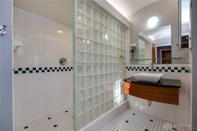 bathroom featuring sink, tasteful backsplash, tile walls, a tile shower, and tile patterned flooring