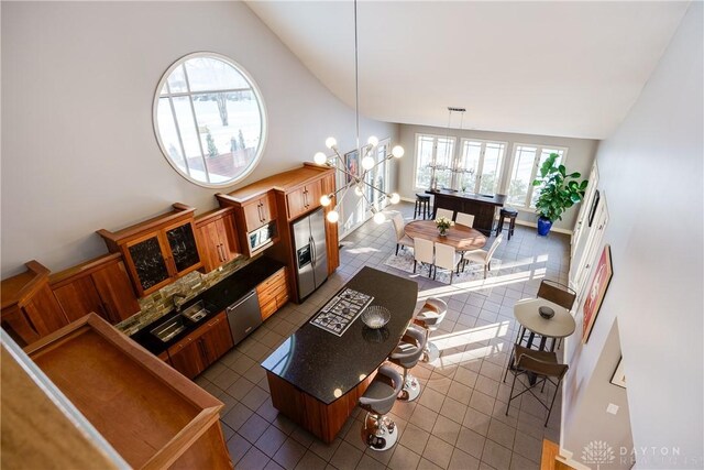 living room with dark tile patterned floors, vaulted ceiling, and a chandelier