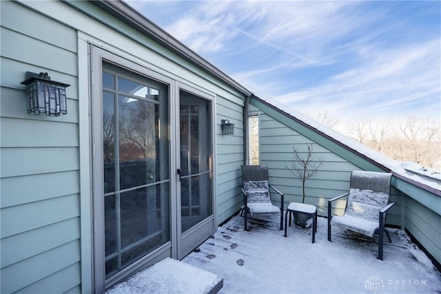 view of snow covered back of property