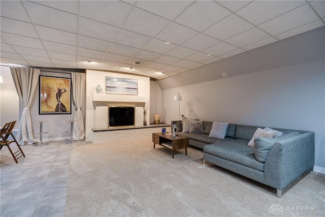 living room featuring carpet floors and a drop ceiling